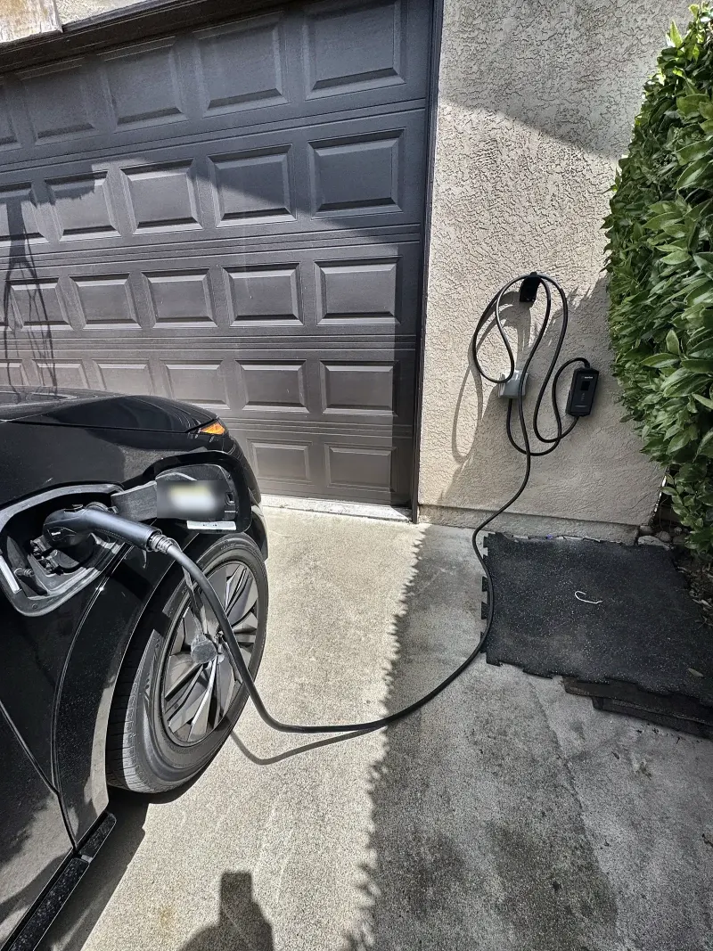 Level 2 EV charger installed beside a San Diego garage door, charging an electric car