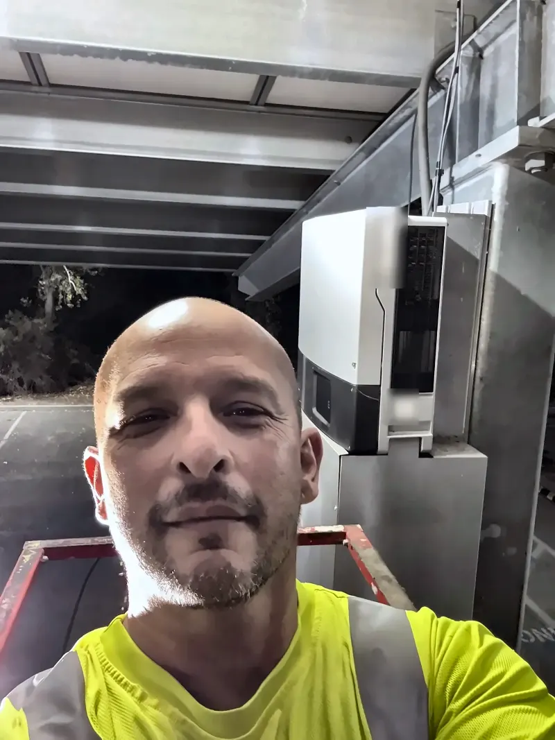 Luis of LTBL Energy servicing a commercial solar carport inverter in San Diego County