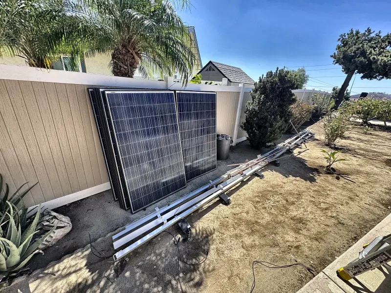 Removed solar panels and racking stored in the yard during a San Diego roof replacement